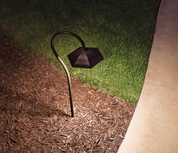 Closeup of outdoor floor light along a residential sidewalk at night - Landscape lighting Orlando