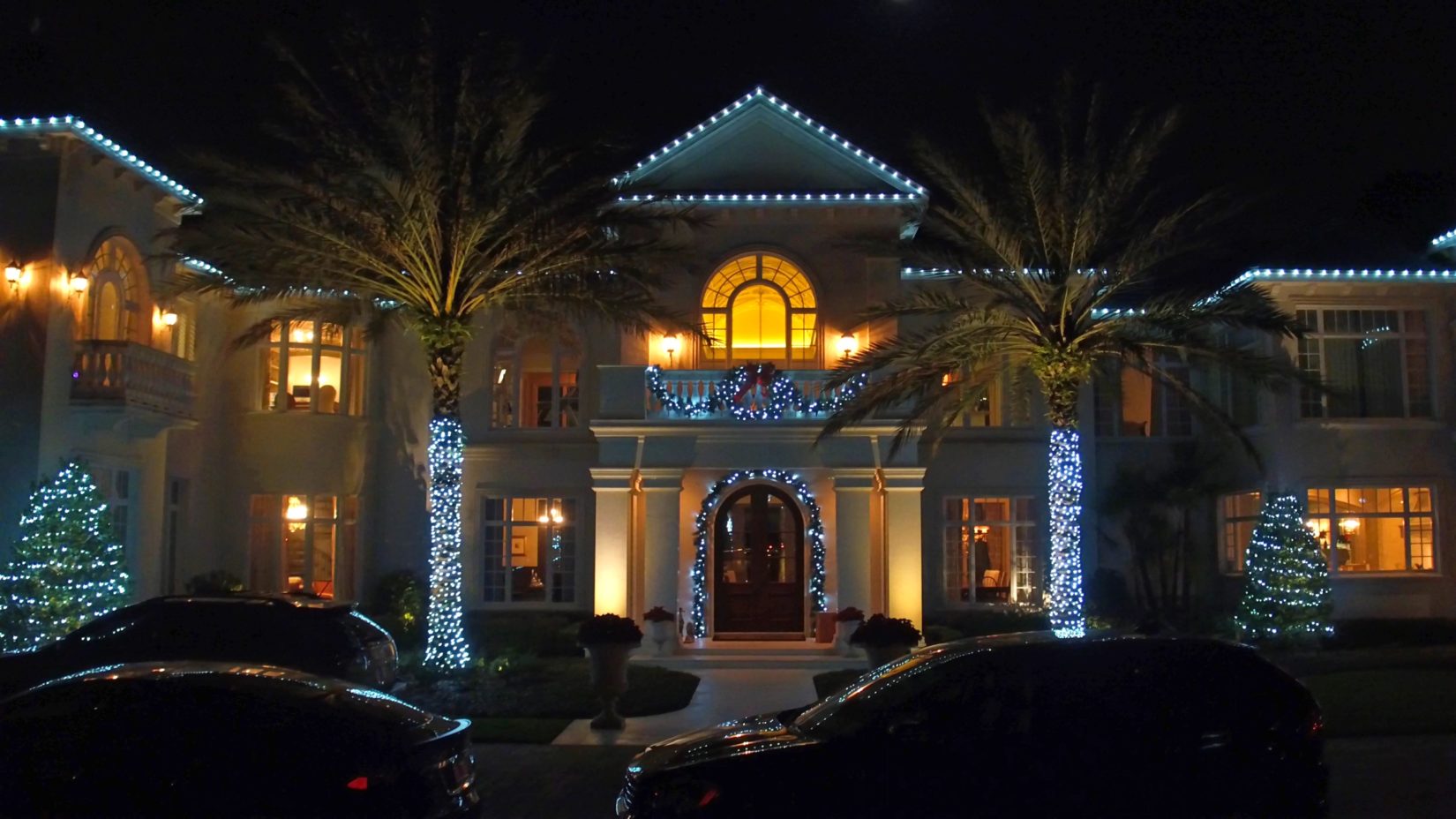 Holiday outdoor lighting design on large two-story home at night - Landscape lighting Orlando