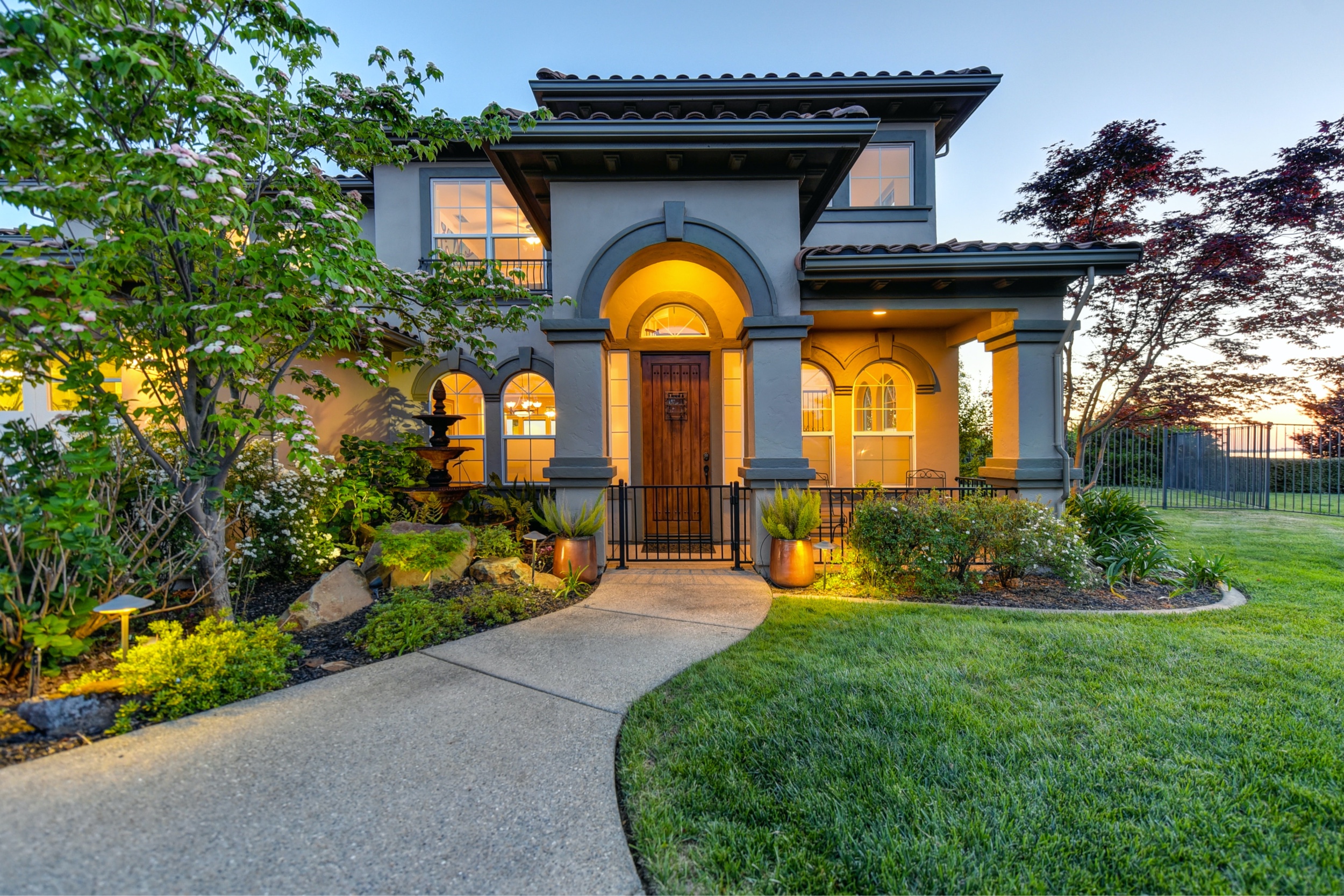 Residential lighting design on two-story home at sunset - Landscape lighting Orlando