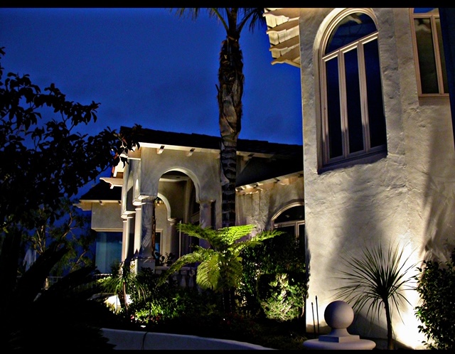 Residential landscape lighting along perimeter of large home at night