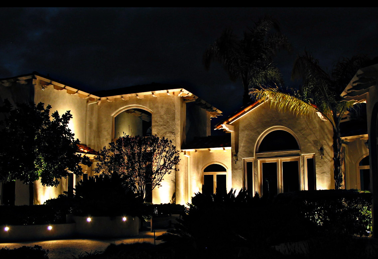 Residential landscape lighting on large home at night