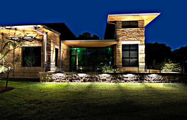 Residential landscape lighting surrounding large home at night